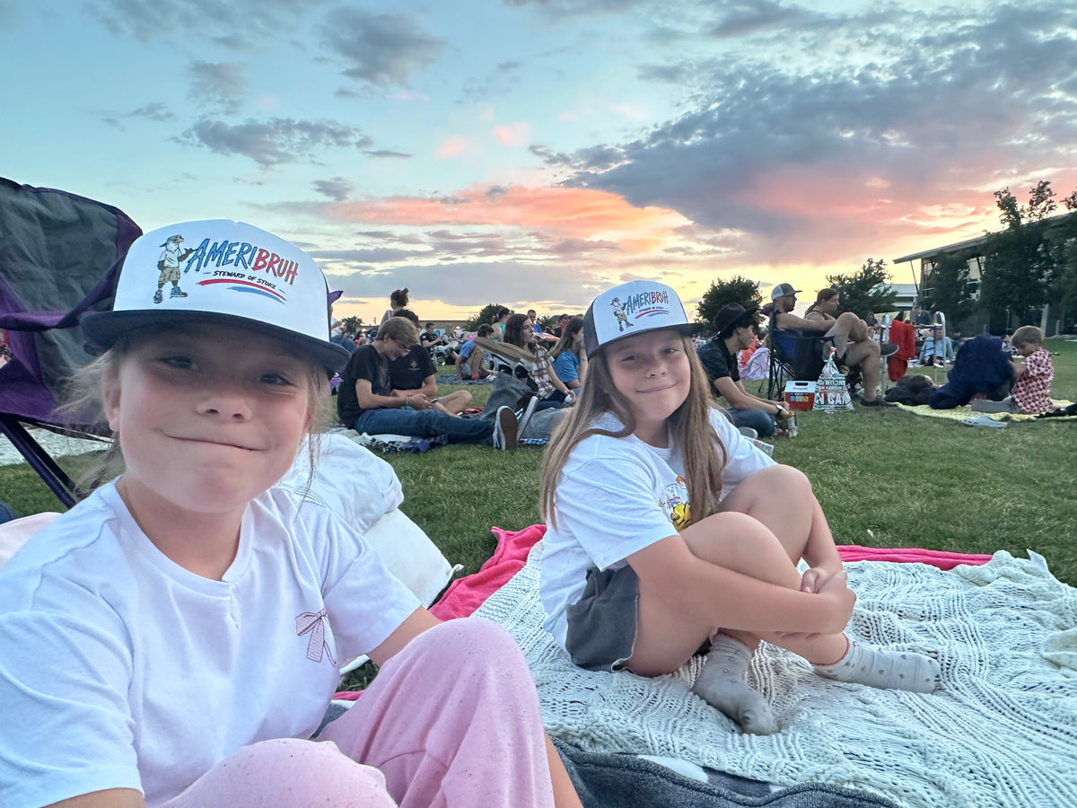 Kids wearing Ameribruh trucker hats at sunset